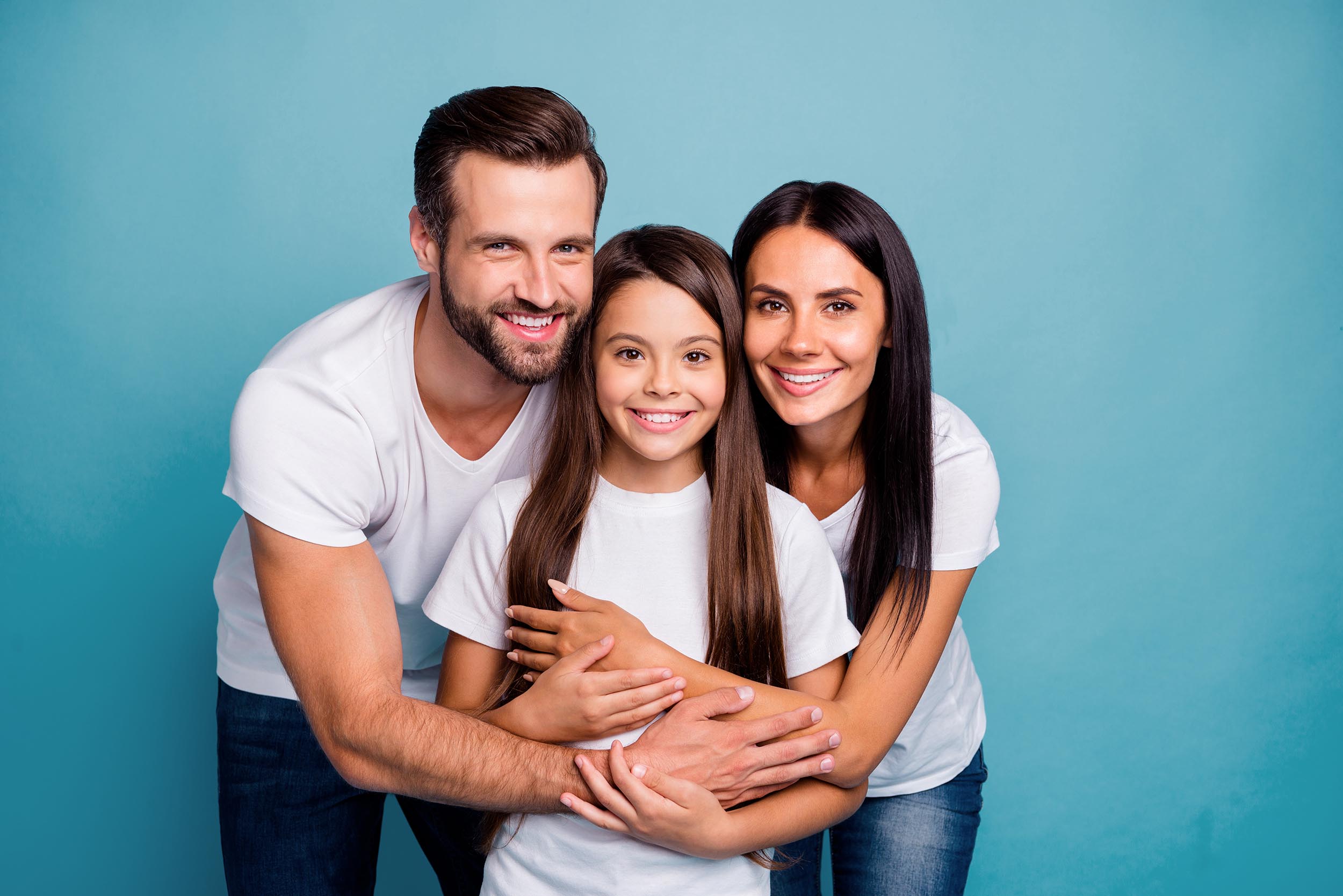 Portrait of lovely adult guy woman and cute kid hug piggyback wearing white t-shirt denim jeans isolated over blue background dental exams and cleanings in houston tx - adonia dentistry