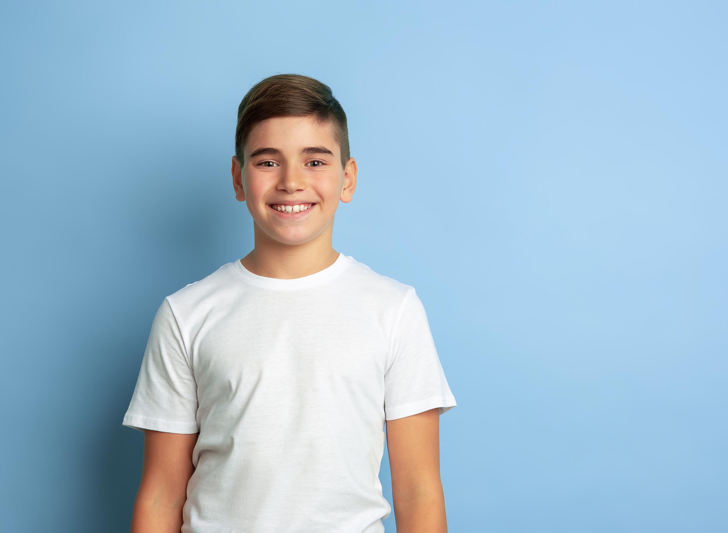 Caucasian teen's portrait isolated on blue studio background orthodontic treatment in houston tx - adonia dentistry